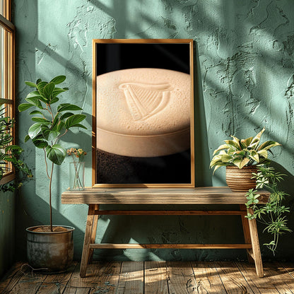 A vertical macro photograph of the thick, creamy foam head on a pint of Guinness. The iconic Guinness harp is embossed into the center of the velvety bubbles. The image features warm cream tones against a dark, shadowy background.