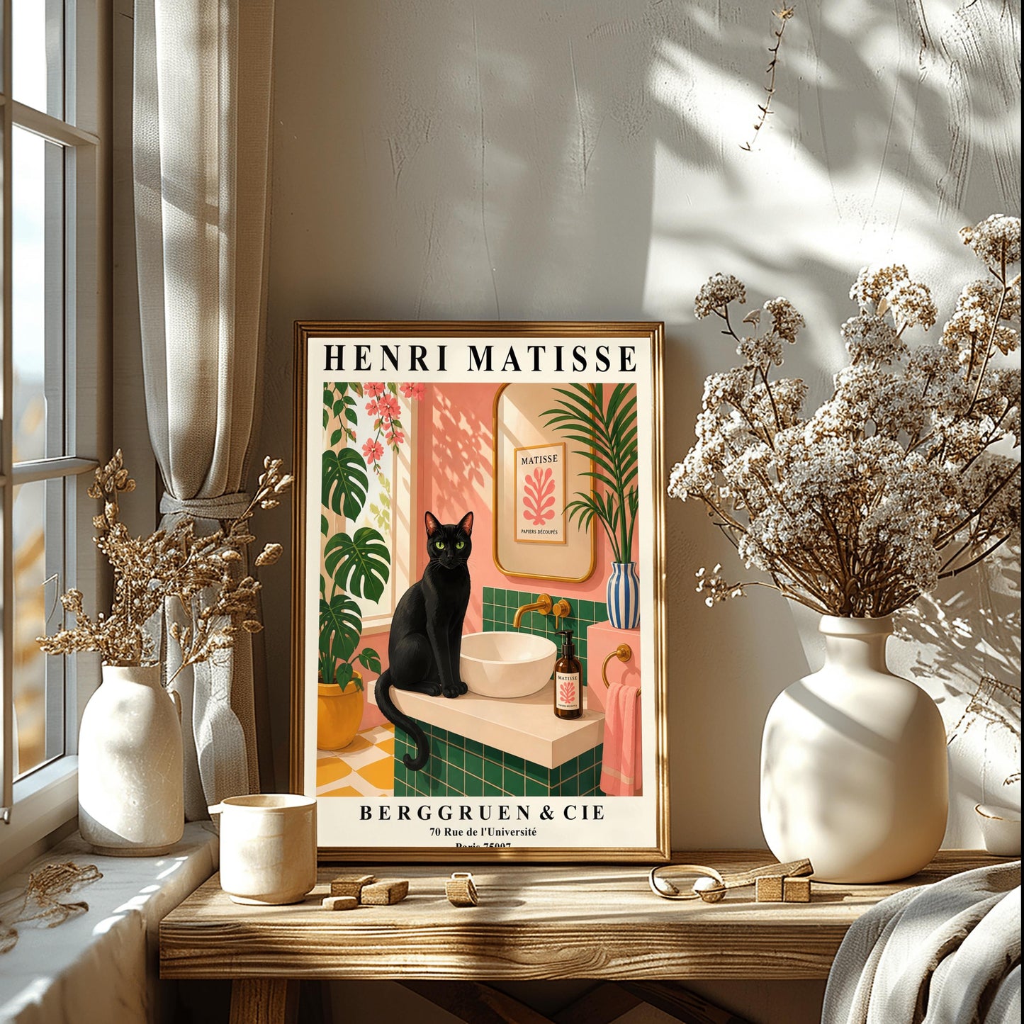 A vertical art print styled as a Henri Matisse exhibition poster. A sleek black cat with bright green eyes sits on a cream-colored bathroom vanity next to a white vessel sink. The bathroom features blush pink walls and emerald green tiles. A gold-framed mirror reflects a Matisse leaf print. Lush green plants and pink flowers frame the scene, and dappled sunlight creates shadows on the wall. The poster has bold black text at the top and bottom with the gallery name Berggruen & Cie.