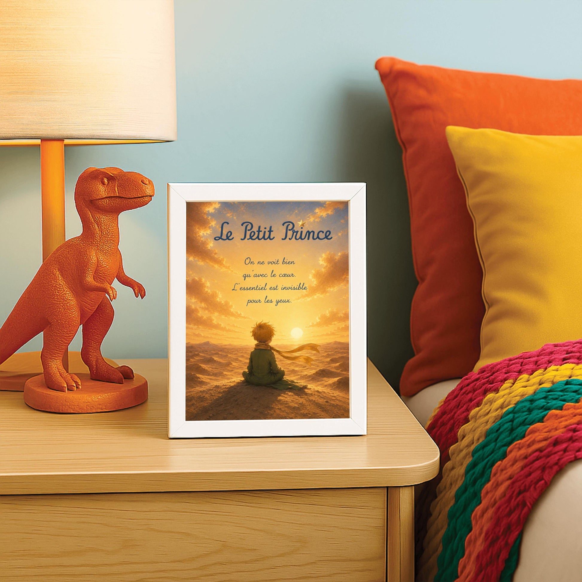 A vertical illustration of the Little Prince from behind, sitting on top of a desert sand dune. He has messy blond hair, wears a green suit, and a long golden yellow scarf that blows to the right. He looks out toward a glowing sun setting on a vast, texturized desert horizon under a dramatic golden sky.