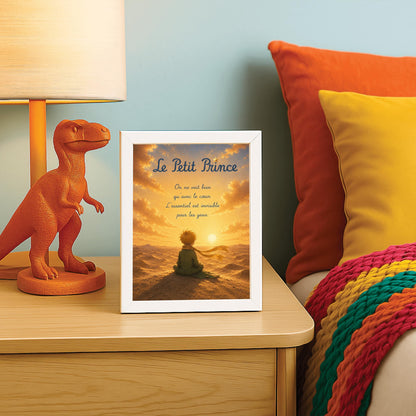 A vertical illustration of the Little Prince from behind, sitting on top of a desert sand dune. He has messy blond hair, wears a green suit, and a long golden yellow scarf that blows to the right. He looks out toward a glowing sun setting on a vast, texturized desert horizon under a dramatic golden sky.