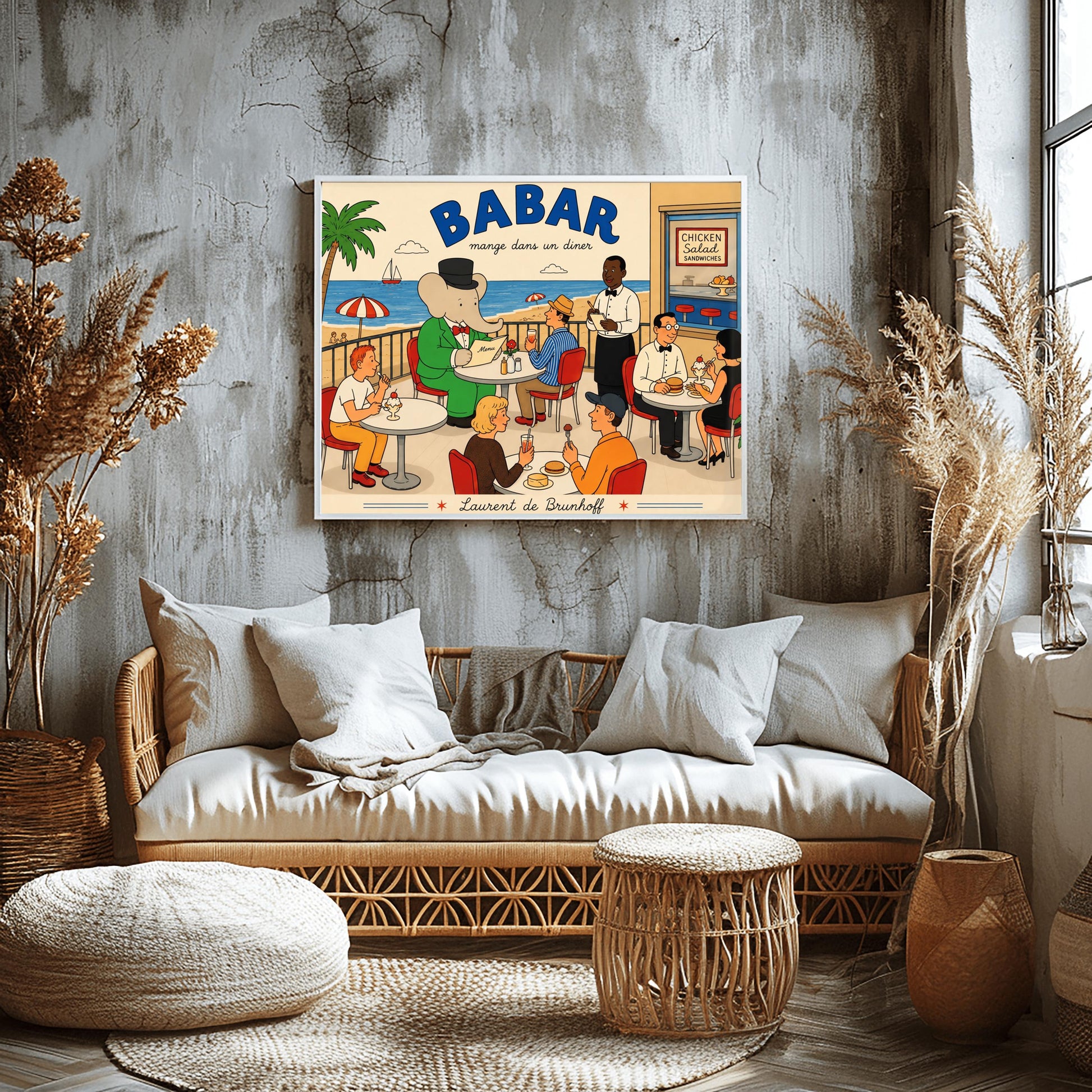 A bright 1950s-style illustration poster titled "BABAR mange dans un diner" in bold blue and black script. The scene shows an outdoor diner balcony overlooking a sandy beach and blue ocean with a sailboat. On the left, the cartoon elephant King Babar sits at a round white table in a green suit and top hat, reading a menu. Several other patrons are seated at tables on red chairs eating burgers and ice cream sundaes, while a waiter in a bowtie takes notes.
