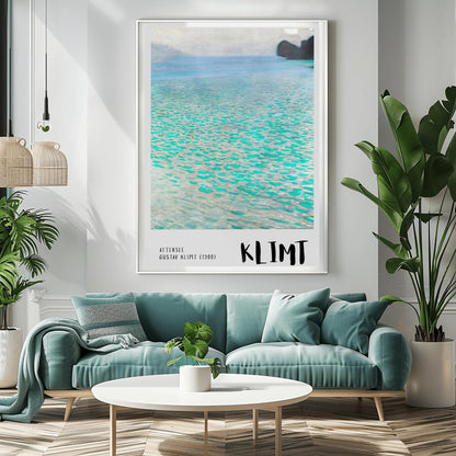 A vertical museum exhibition poster featuring Gustav Klimt's 1900 landscape painting "Attersee." The image depicts a close-up, shimmering view of a turquoise lake with a small dark island in the top right. The bottom border is soft grey with bold black text reading "ATTERSEE" and "KLIMT."