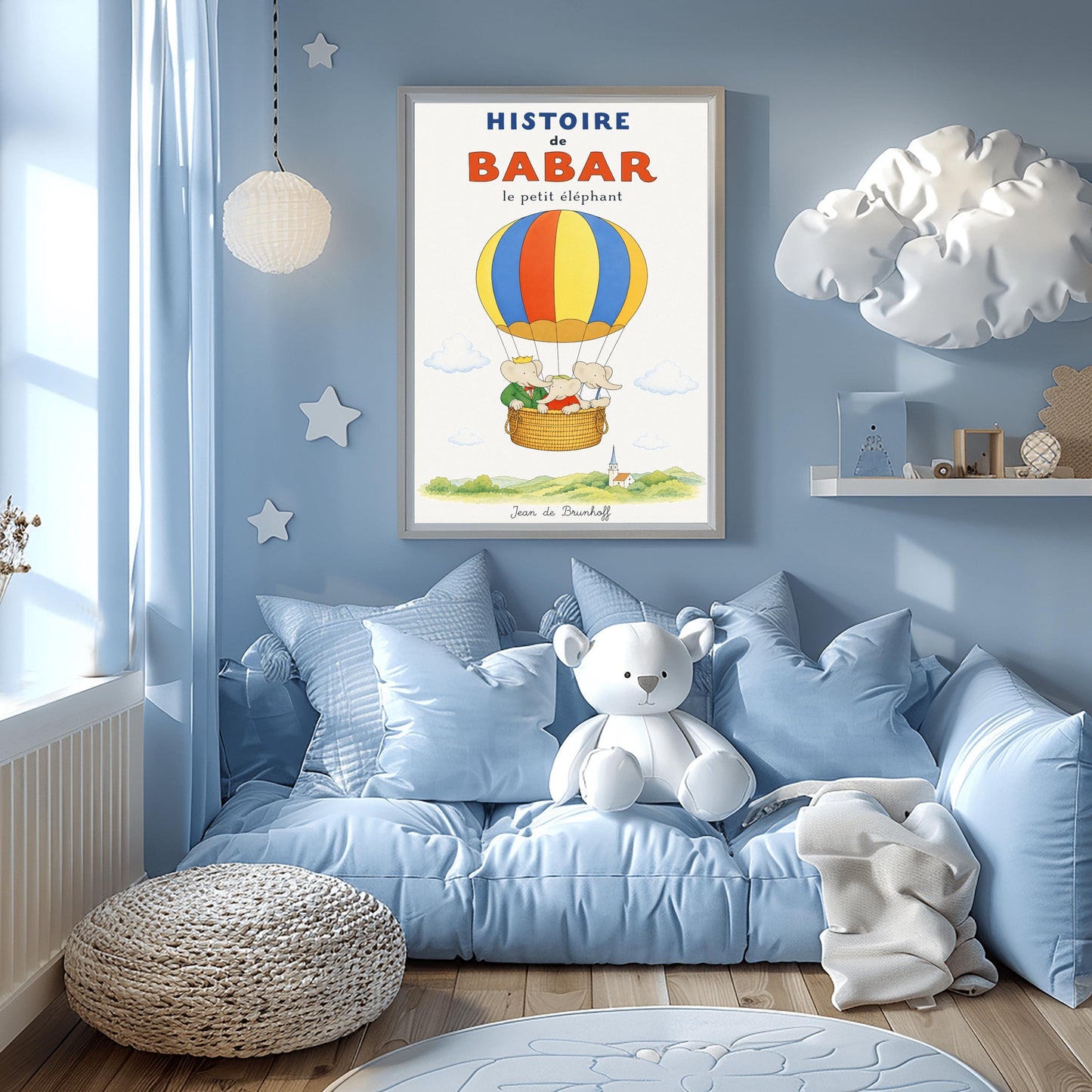 A vertical vintage-style storybook poster on an off-white background titled "HISTOIRE de BABAR le petit éléphant" in bold blue and orange font. The illustration features a large hot air balloon with yellow, blue, and orange stripes floating in a sky with soft clouds. Inside the wicker basket, three cartoon elephants ride together. On the left, King Babar wears a green suit and crown while pointing ahead. The other two young elephants wear red and white shirts.