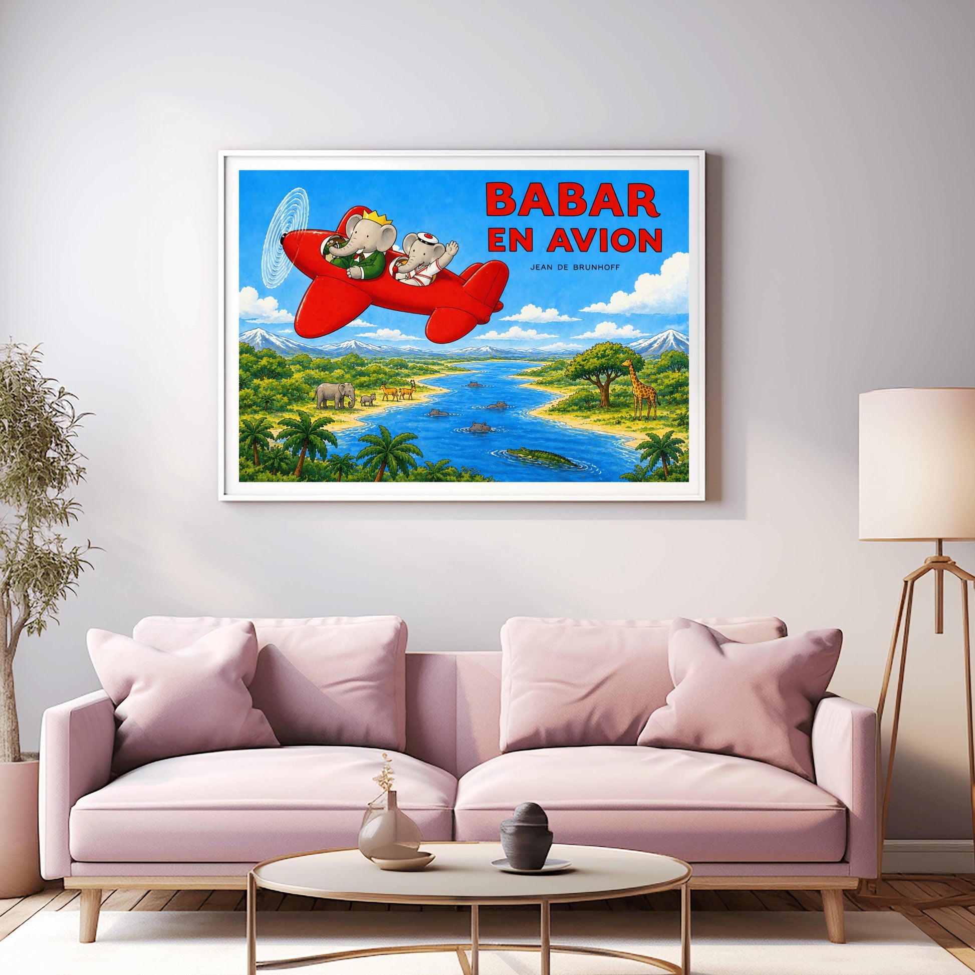 A horizontal watercolor-style illustration of Babar the Elephant flying a bright red propeller plane. Babar wears a green suit and crown, while a smaller elephant in a white sailor suit waves from the back seat. They fly over a vibrant safari landscape with a winding blue river filled with hippos and a crocodile. On the riverbanks are giraffes, antelopes, elephants, and palm trees. Snow-capped mountains rise in the distance under a blue sky. Large red text reads "BABAR EN AVION."