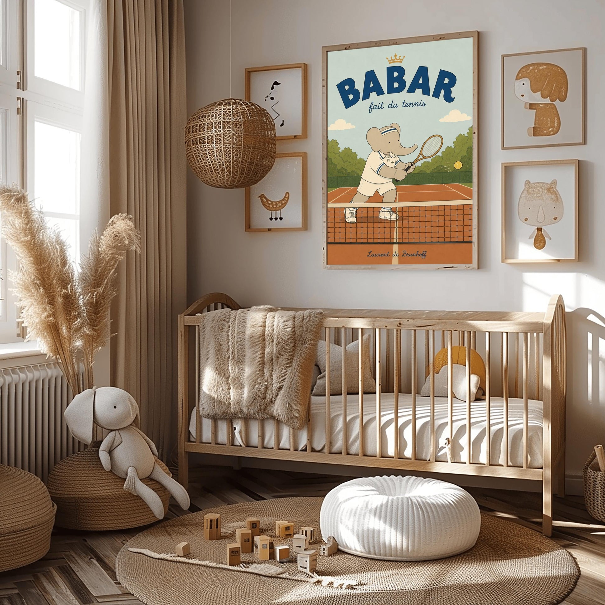 A vertical storybook-style art print featuring Babar the Elephant playing tennis. Babar is seen behind a tennis net on an orange clay court, holding a wooden racket in a backhand swing. He wears a white polo with blue stripes, white shorts, and a blue-and-white striped headband. A yellow tennis ball is in mid-air. The background has green trees and a light blue sky. The top reads "BABAR fait du tennis" with a small gold crown.