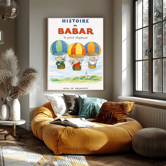 A vertical children's illustration poster titled "HISTOIRE de BABAR le petit éléphant" at the top. It features three hot air balloons with blue, orange, and yellow stripes floating over a green landscape with a small church. Three elephants, including one in a green suit and crown (Babar), look out from the baskets and wave. The background is a soft off-white with light clouds. The name "JEAN DE BRUNHOFF" is at the bottom.
