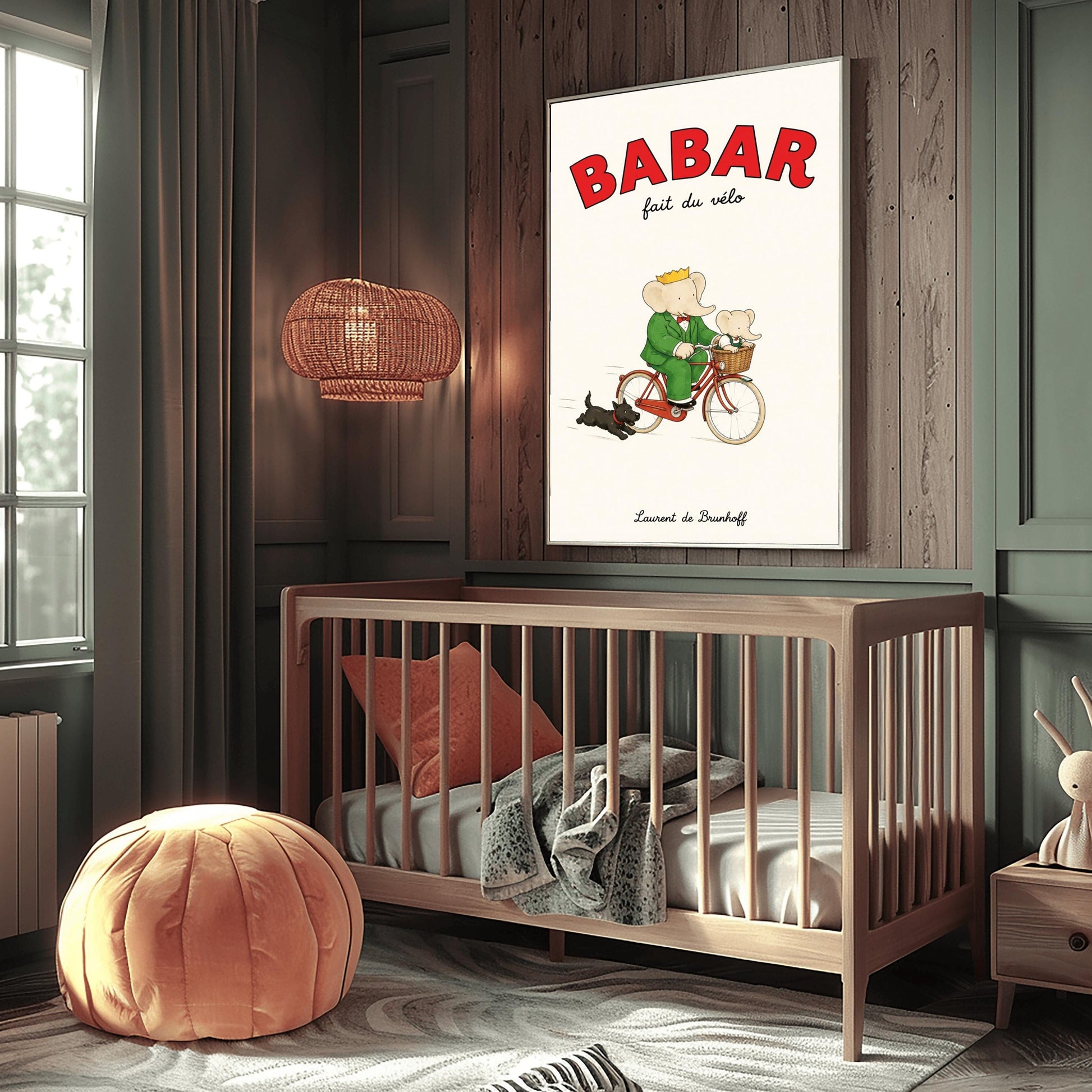 A vertical retro fine art exhibition poster titled "BABAR fait du vélo" on a wide cream border. The top "BABAR" text is printed in a bold red font. The illustration shows an elephant wearing a crown and green suit riding a vintage red bicycle. A smaller baby elephant is sitting inside a brown wicker basket on the handlebars, and a small black dog runs along beside the bike. The name "Laurent de Brunhoff" anchors the bottom.