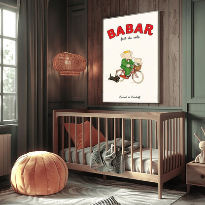A vertical retro fine art exhibition poster titled "BABAR fait du vélo" on a wide cream border. The top "BABAR" text is printed in a bold red font. The illustration shows an elephant wearing a crown and green suit riding a vintage red bicycle. A smaller baby elephant is sitting inside a brown wicker basket on the handlebars, and a small black dog runs along beside the bike. The name "Laurent de Brunhoff" anchors the bottom.