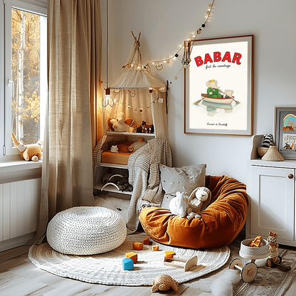 A vertical retro fine art exhibition poster titled "BABAR fait du canotage" on a wide cream border. The top "BABAR" text is printed in a bold red font. The illustration shows an elephant wearing a crown and green suit sitting in a white wooden rowboat with a red rim, holding two oars. A smaller elephant leans over the front of the boat looking at its reflection in the calm water. The name "Laurent de Brunhoff" anchors the bottom.