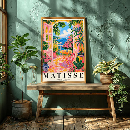 A vertical maximalist art print styled as a Henri Matisse exhibition poster. The scene features a vibrant balcony with pink-framed glass doors open to a view of the blue Mediterranean sea and a coastal town. The balcony has pink and yellow checkered tiles, a yellow round table with a pink chair, and is filled with tropical plants and pink flowers in blue and white vases. A sailboat is visible on the water under a bright blue sky with white clouds.