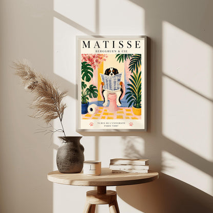 A vertical vintage-style exhibition poster on a cream background titled "MATISSE BERGGRUEN & CIE" in bold black font. The main gouache-style illustration depicts a tricolor black, white, and tan Cavalier King Charles Spaniel sitting on a pink toilet. The dog is holding and reading a blue-and-white French newspaper titled "LE JOURNAL". The bathroom scene includes a roll of toilet paper on a yellow checkered floor, potted monstera and palm plants