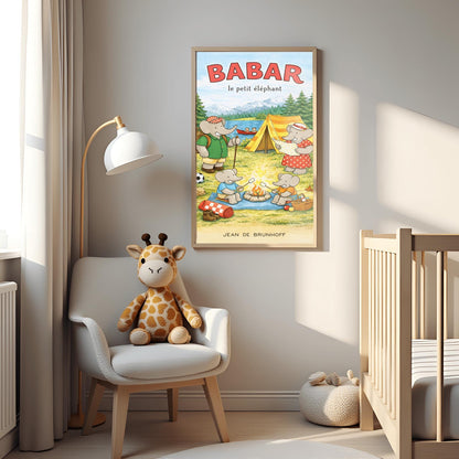 A vertical children's illustration poster titled "BABAR le petit éléphant" at the top in red. It features an elephant family camping by a lake. A large elephant (Babar) in a green shirt stands to the left with a backpack and walking stick. Another large elephant (Celeste) in a red polka-dot dress looks at a map near a yellow tent. Two small elephants sit in the foreground roasting marshmallows over a campfire. The background shows a lake with a red canoe and snow-capped mountains.