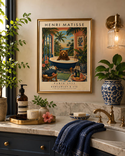 A vertical retro Henri Matisse exhibition poster on a wide cream border. The main image shows a surreal illustration of a large brown bear taking a bubble bath in a navy blue clawfoot tub with gold feet. The bathroom features blue patterned floor tiles, a pink wall with a framed Matisse cut-out poster, and a massive open arch window overlooking a tropical beach with palm trees and a blue ocean at sunset